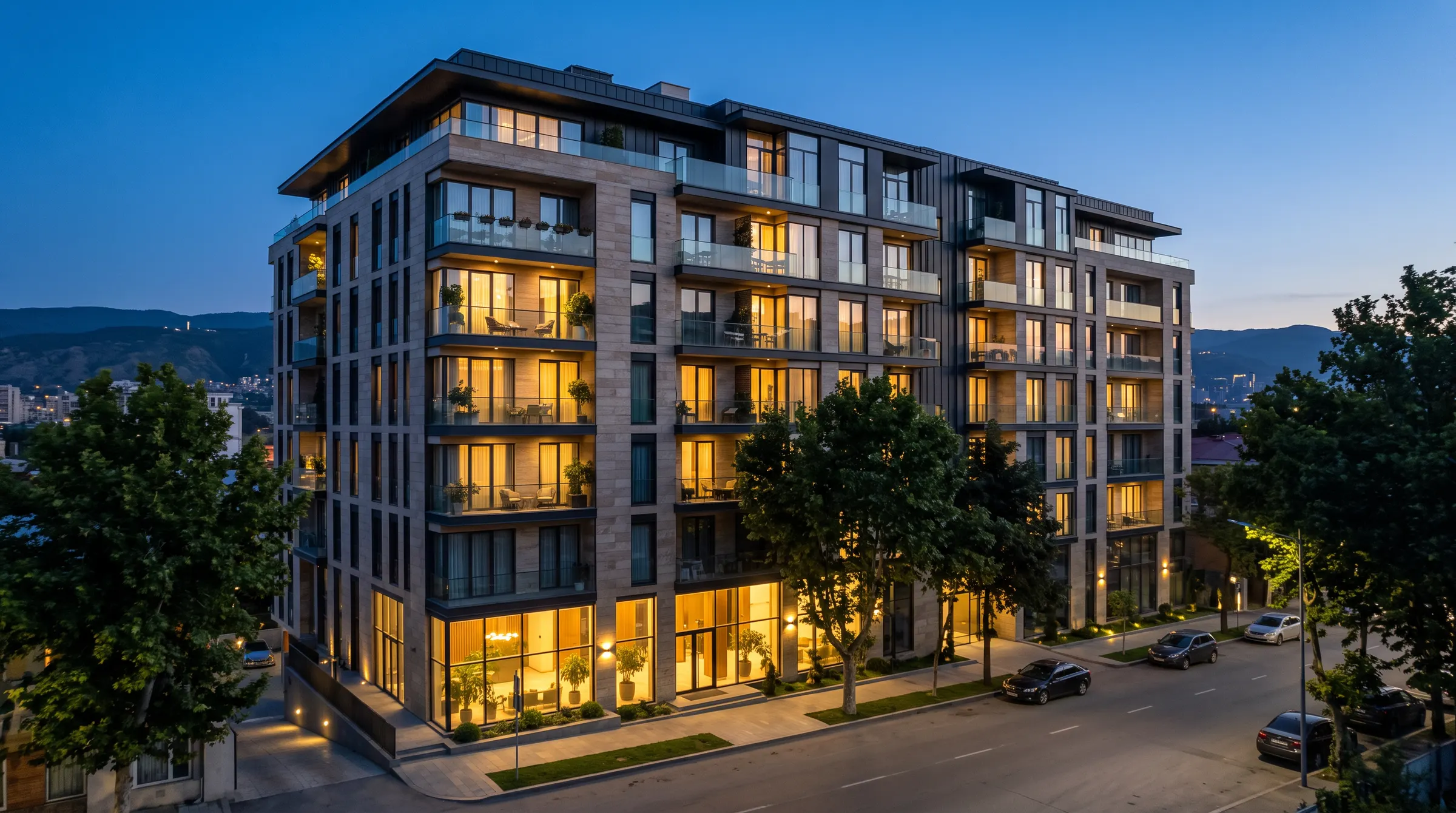An apartment building at dusk with lit windows
